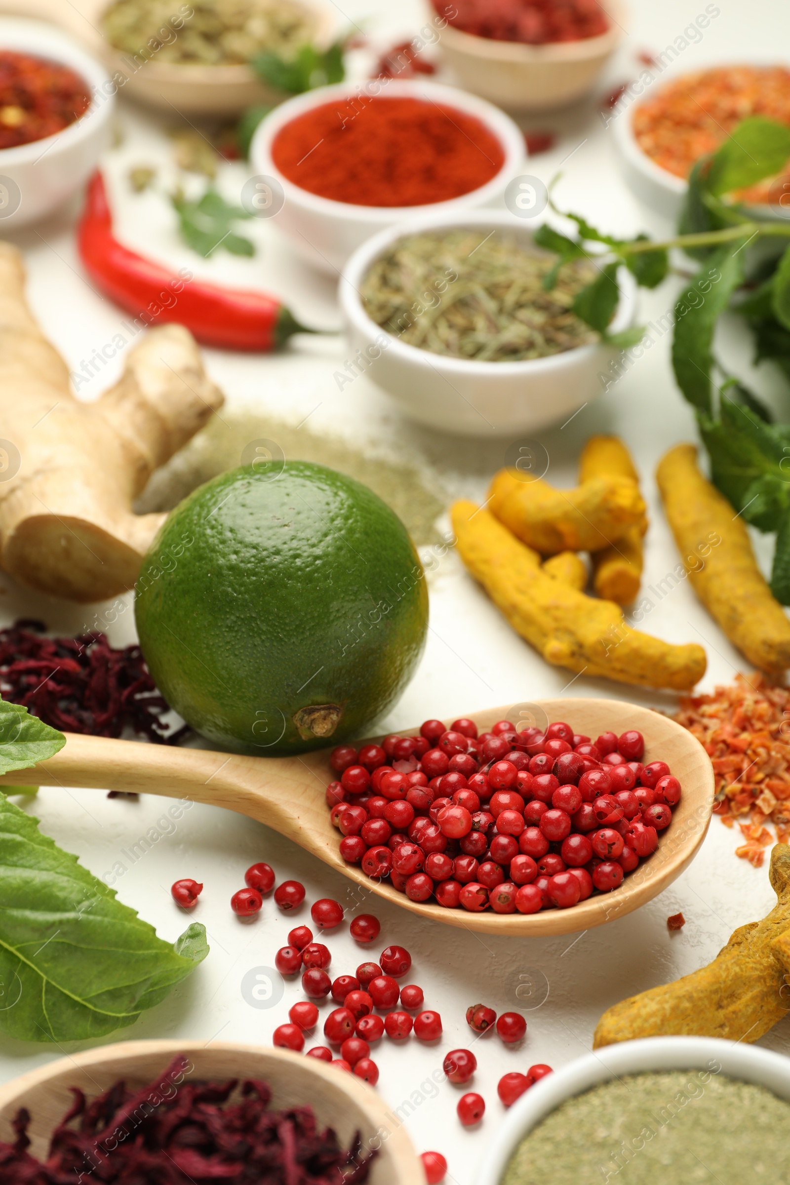 Photo of Different aromatic spices, lime and herbs on white background, closeup