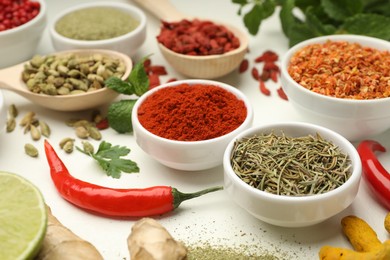 Photo of Different aromatic spices and herbs on white background, closeup