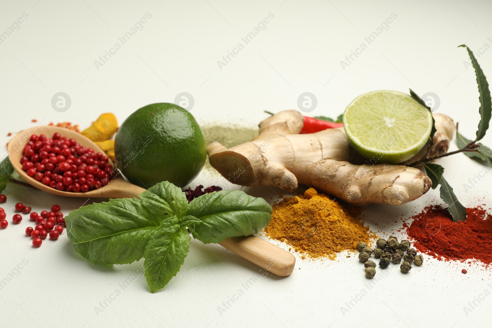 Photo of Different aromatic spices, lime and herbs on white background