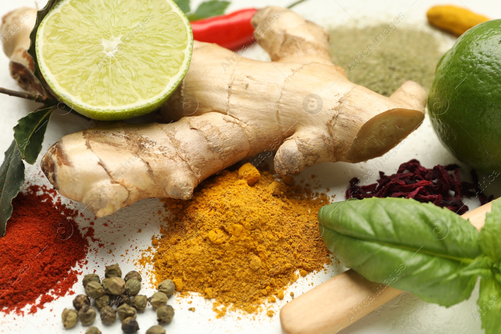 Photo of Different aromatic spices, lime and herbs on white background, closeup