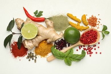 Different aromatic spices, lime and herbs on white background, flat lay