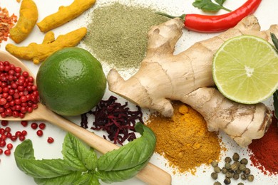 Photo of Different aromatic spices, lime and herbs on white background, closeup