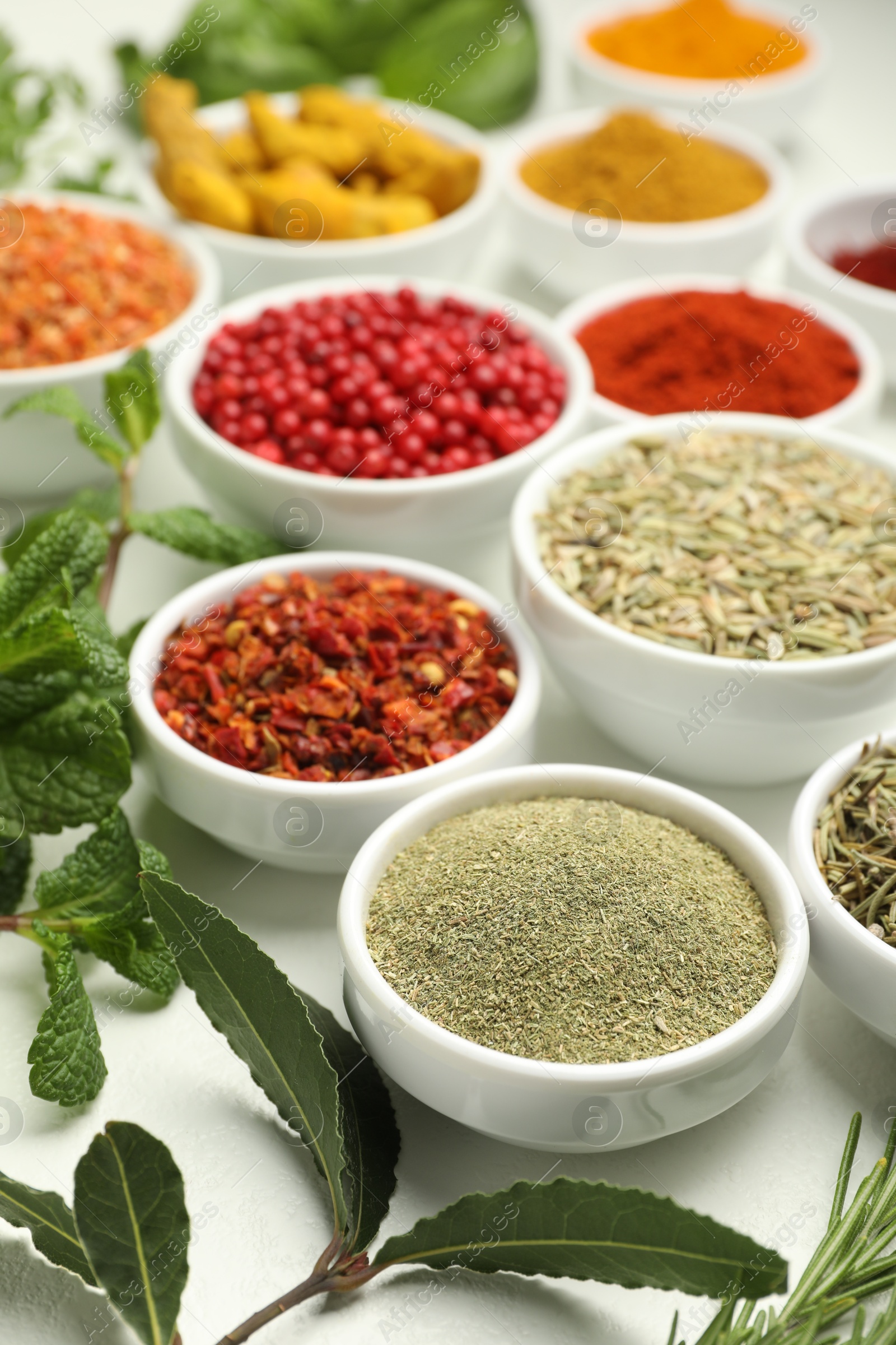 Photo of Different aromatic spices and herbs on white background, closeup