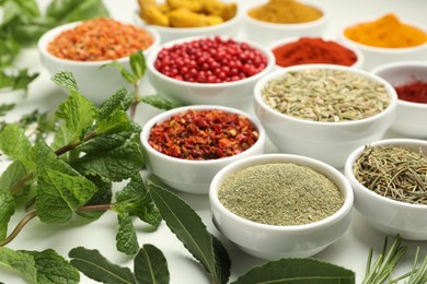 Photo of Different aromatic spices and herbs on white background, closeup