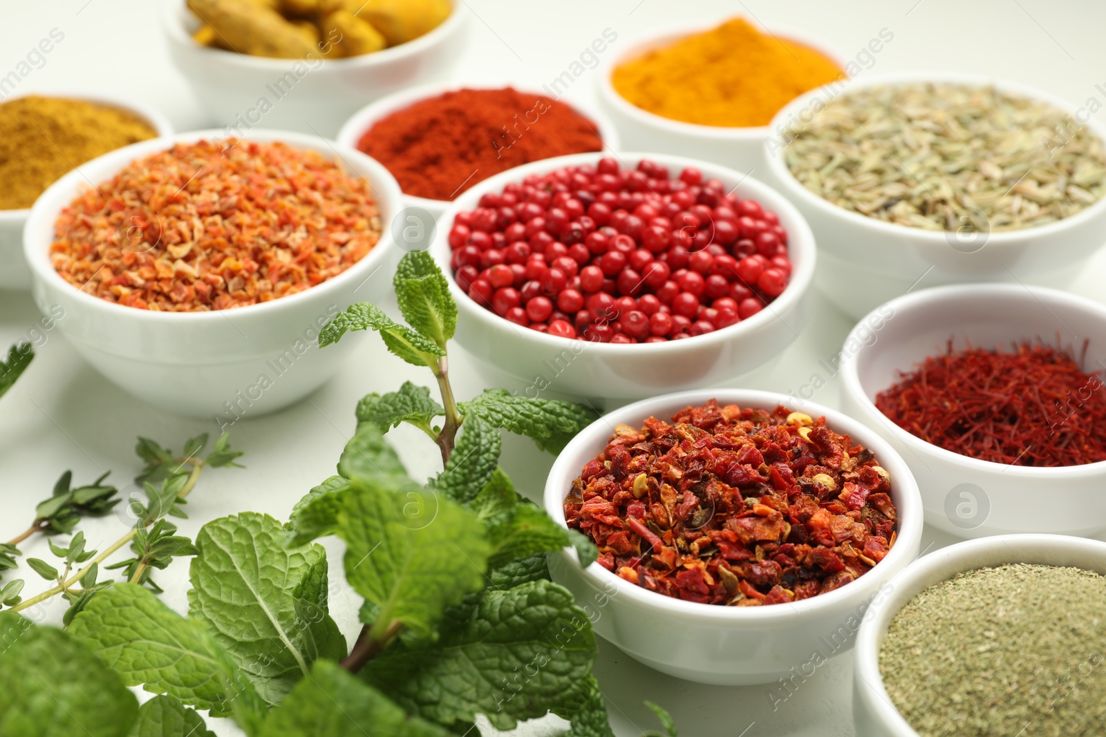 Photo of Different aromatic spices and herbs on white background, closeup