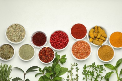 Different aromatic spices and herbs on white background, flat lay