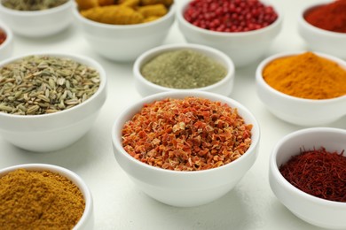 Photo of Different aromatic spices and herbs on white background, closeup