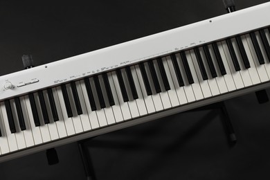 Synthesizer on black background, top view. Electronic musical instrument