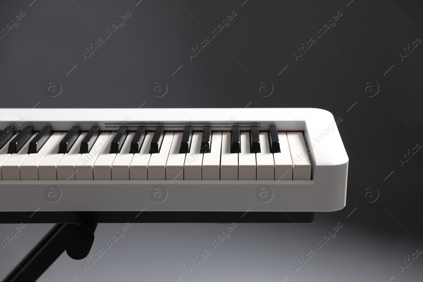 Photo of Synthesizer on grey background, closeup. Electronic musical instrument