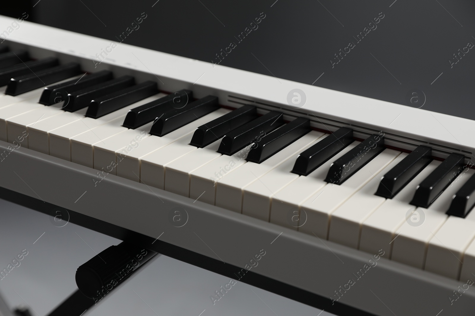 Photo of Synthesizer on grey background, closeup. Electronic musical instrument