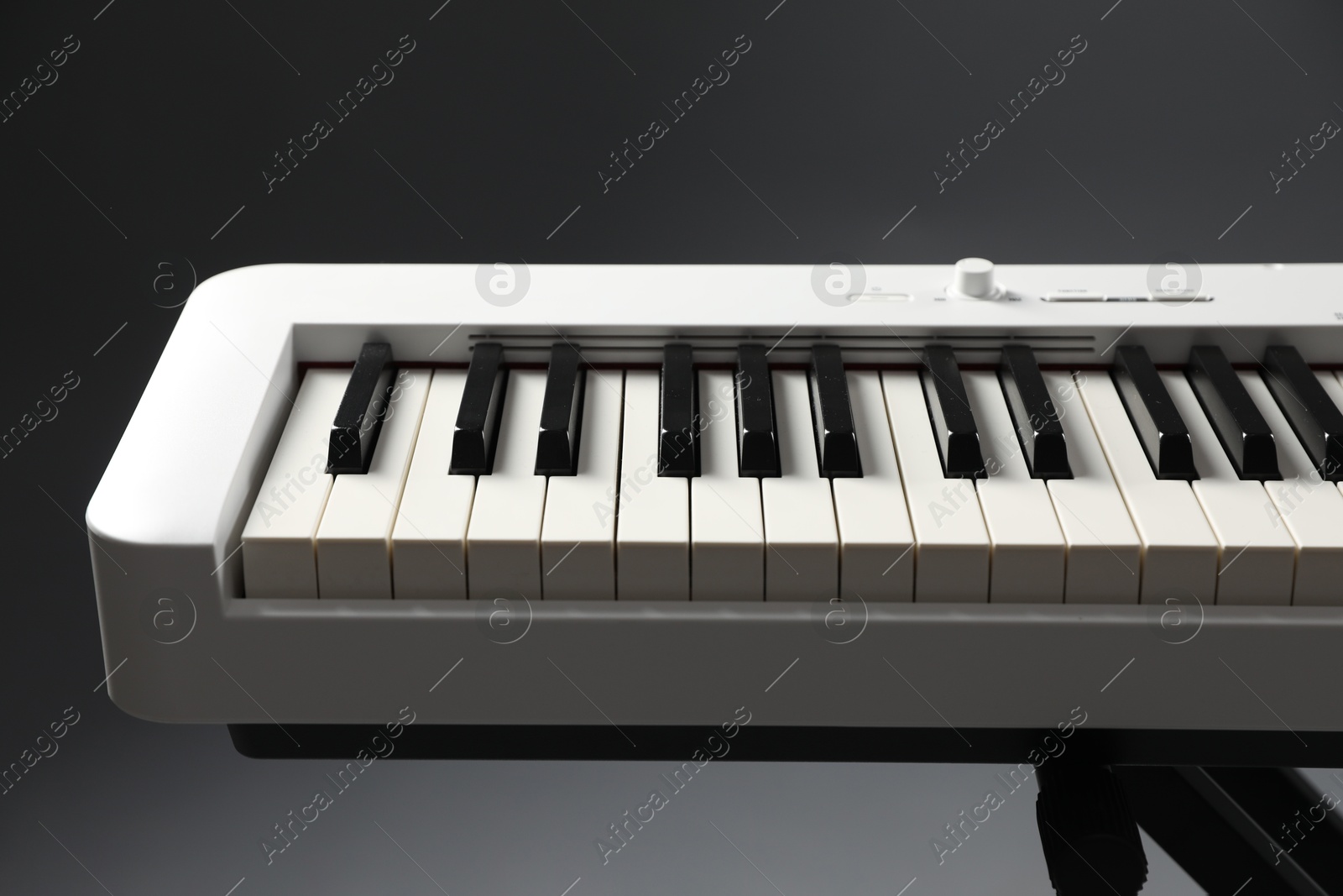 Photo of Synthesizer on grey background, closeup. Electronic musical instrument