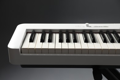 Photo of Synthesizer on grey background, closeup. Electronic musical instrument