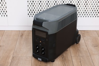 Photo of Modern portable power station on floor indoors