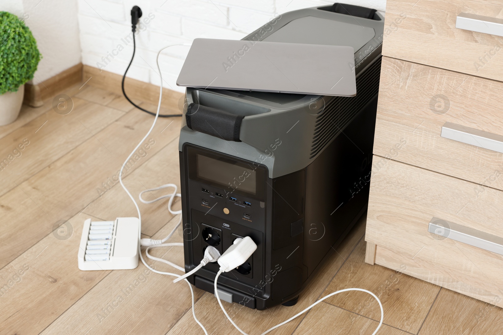 Photo of Modern portable power station, charging attached devices indoors