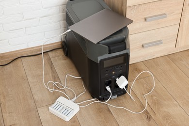 Photo of Modern portable power station, charging attached devices indoors