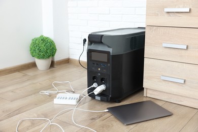 Photo of Modern portable power station, charging attached devices indoors