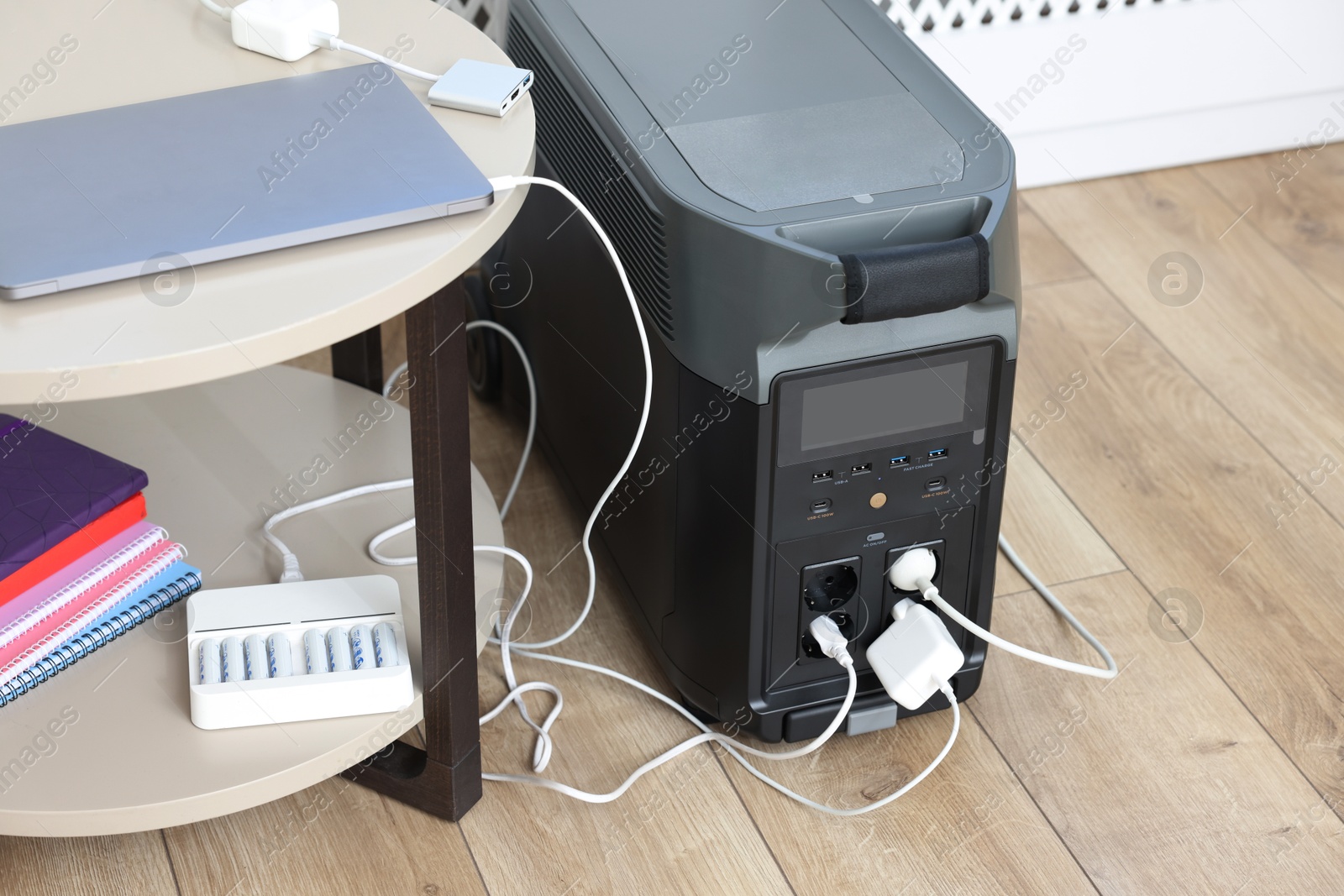 Photo of Modern portable power station, charging attached devices indoors