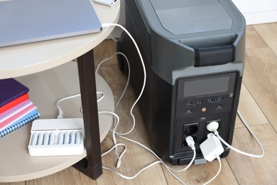 Photo of Modern portable power station, charging attached devices indoors