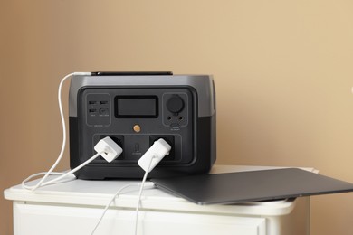 Photo of Devices charging from portable power station on nightstand indoors