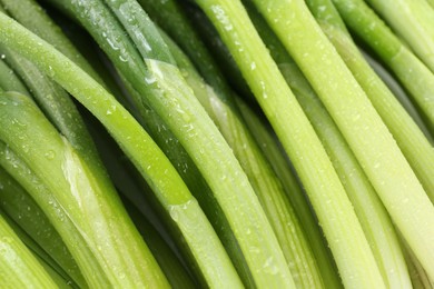 Photo of Many fresh green onions as background, closeup