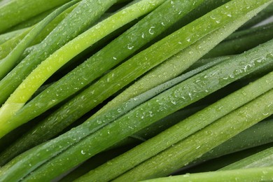 Photo of Many fresh green onions as background, closeup