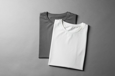 Photo of Different blank t-shirts on grey background, top view. Mockup for design