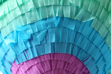 Photo of Pinata. Cut tissue paper in different colors as background, closeup