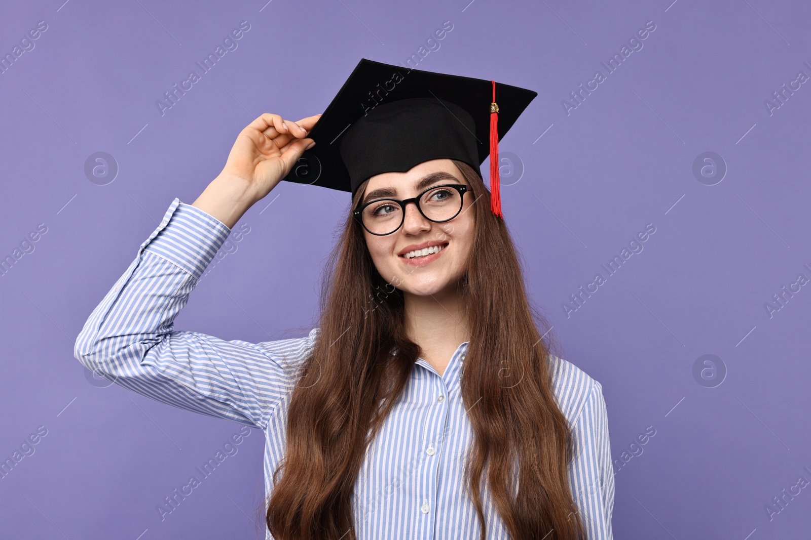 Photo of Happy student after graduation on violet background