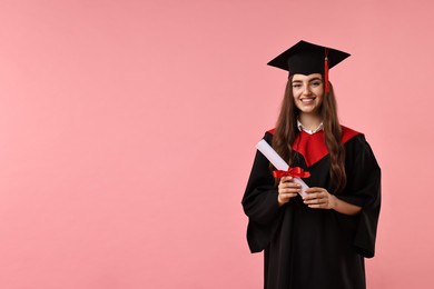 Photo of Happy student with diploma after graduation on pink background. Space for text