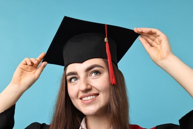 Photo of Happy student after graduation on light blue background