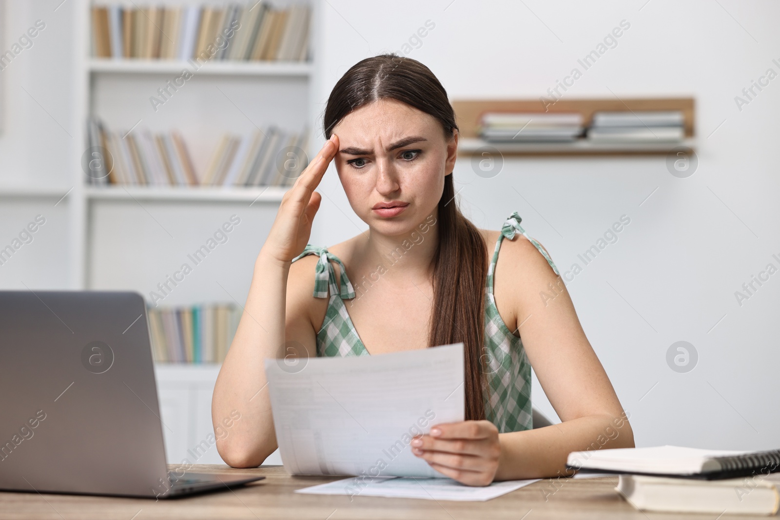 Photo of Tired student having stress before exam at table indoors