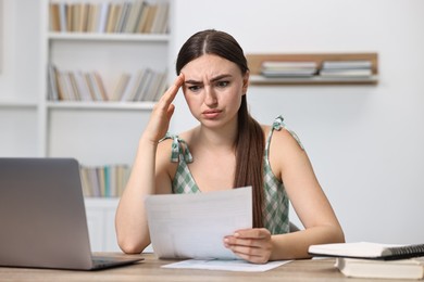 Photo of Tired student having stress before exam at table indoors