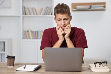 Photo of Tired student having stress before exam at table indoors