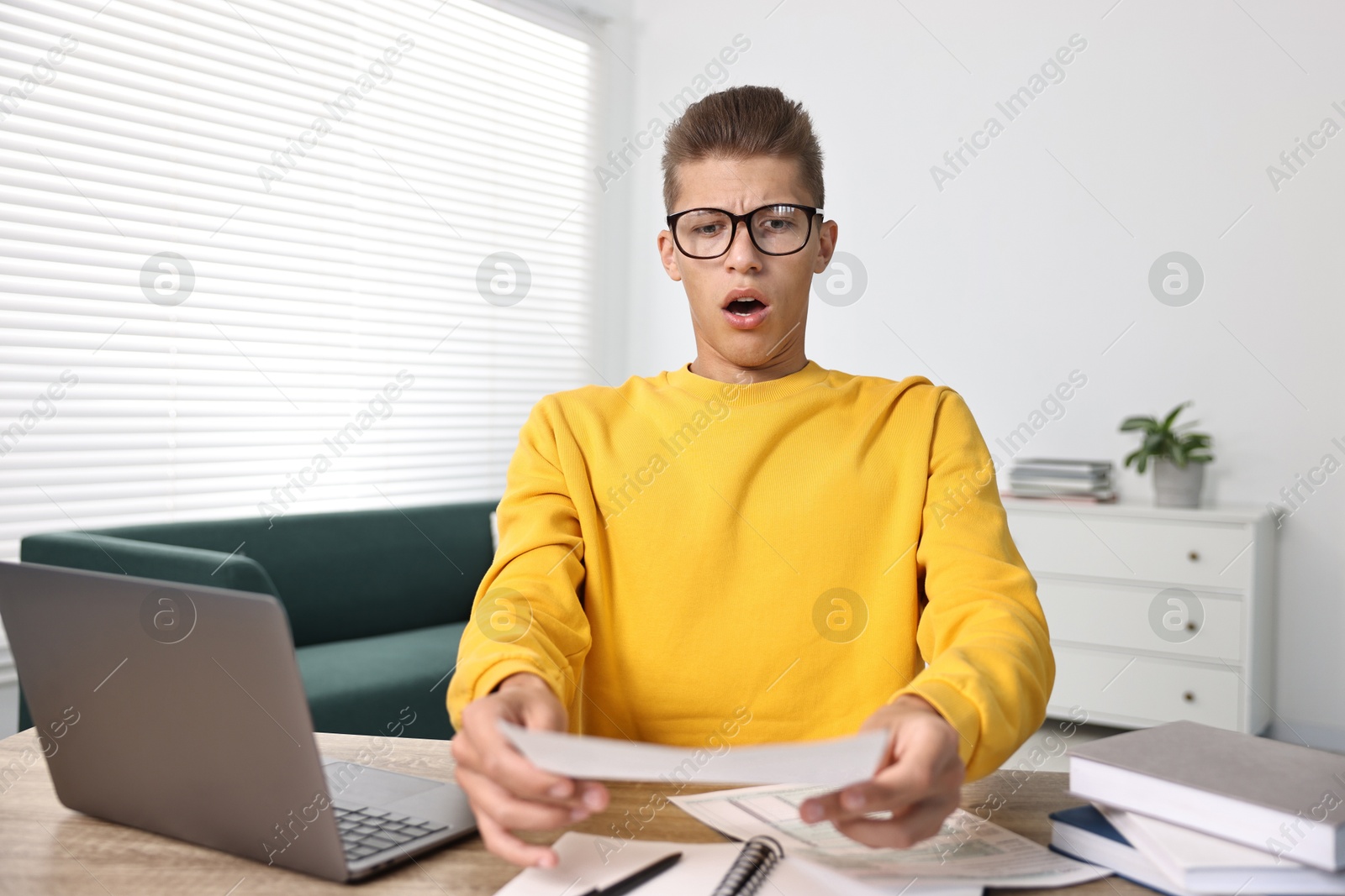 Photo of Emotional student having stress before exam at table indoors