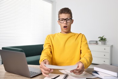 Photo of Emotional student having stress before exam at table indoors