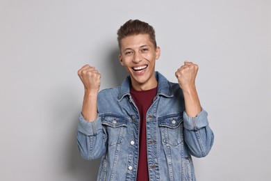 Photo of Student feeling happy about his good exam result on grey background