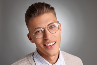 Photo of Handsome young man with stylish haircut on grey background