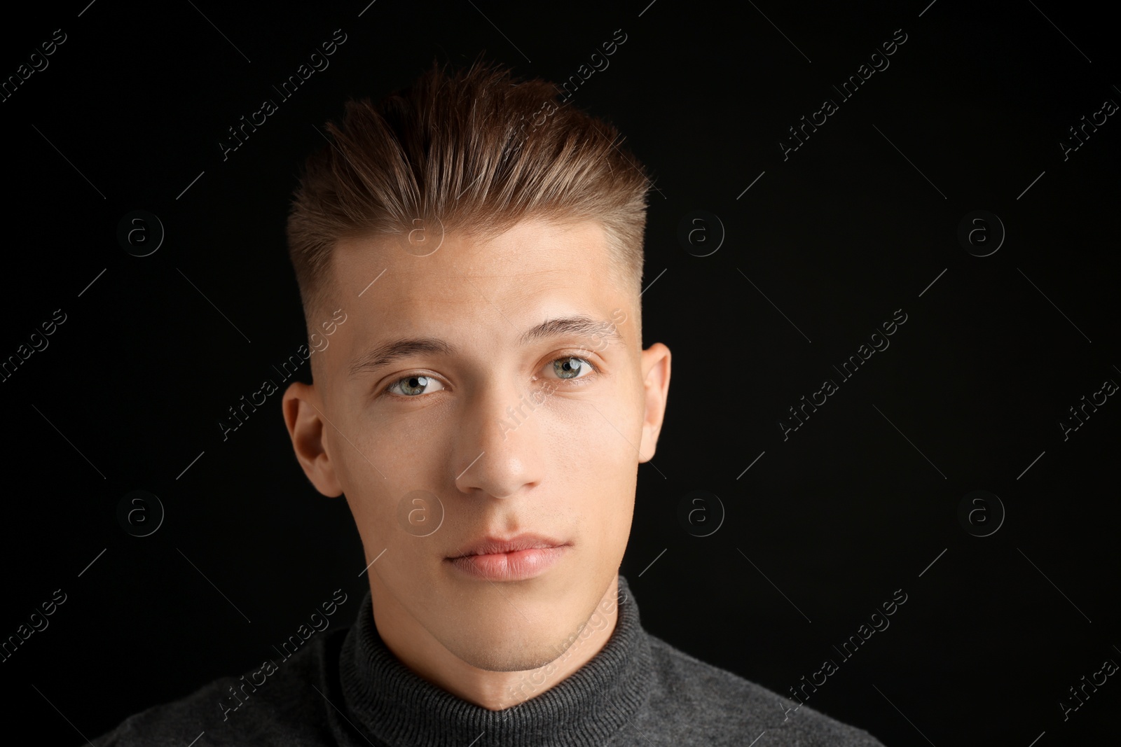 Photo of Confident young man with stylish haircut on black background. Space for text