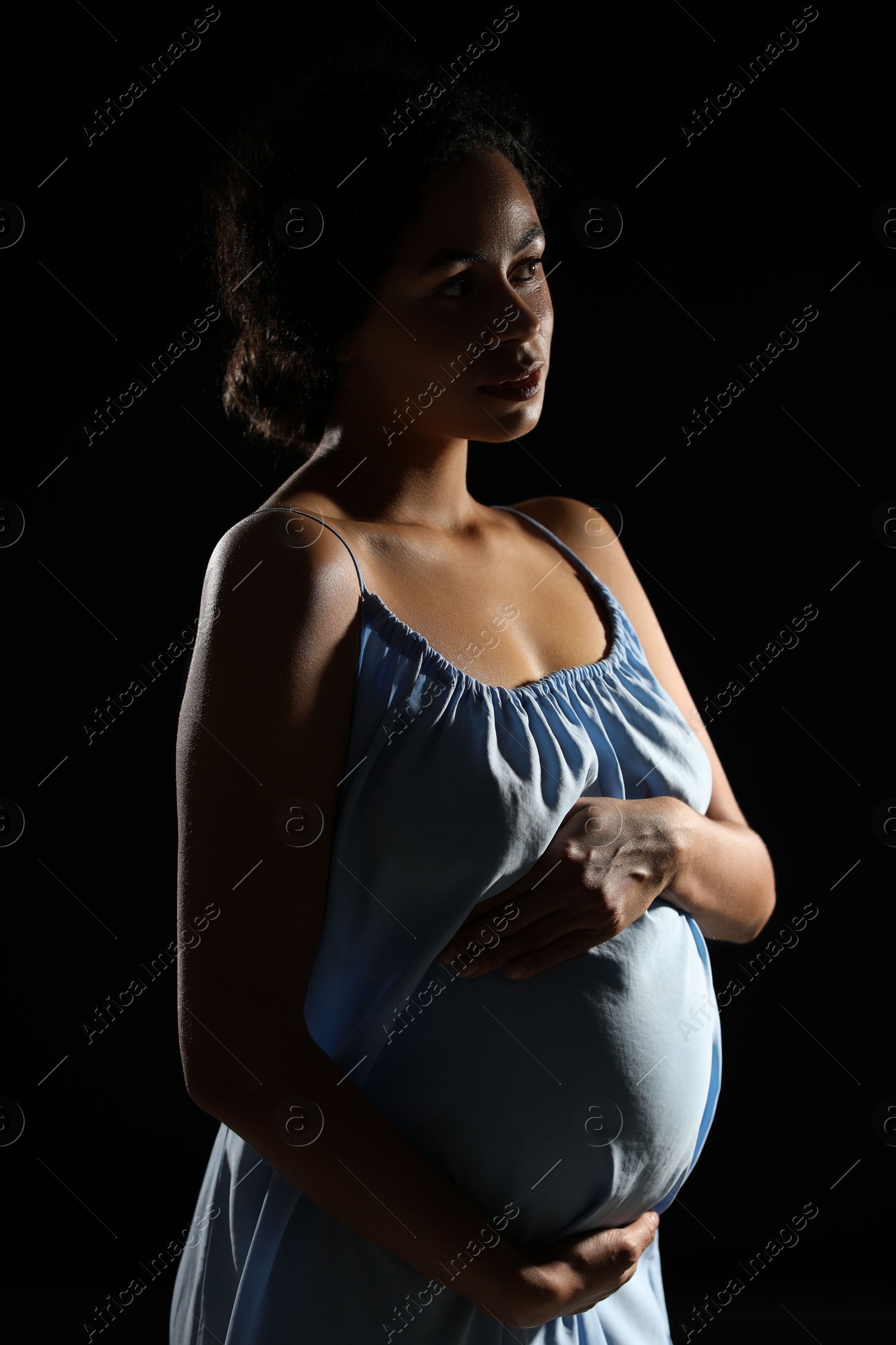 Photo of Portrait of beautiful pregnant woman on black background