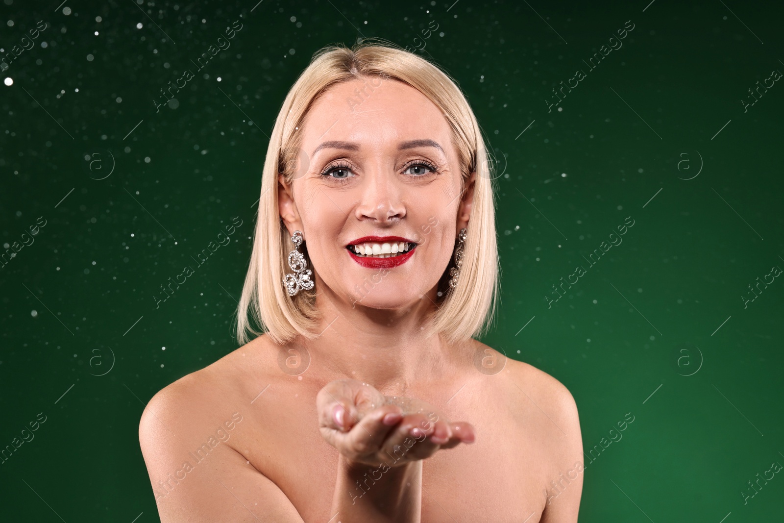 Photo of Happy woman with glitter on green background