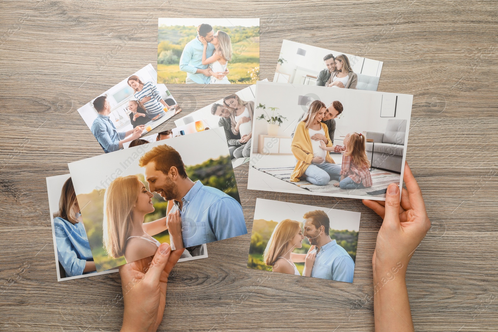 Photo of Woman with different photos at wooden table, top view