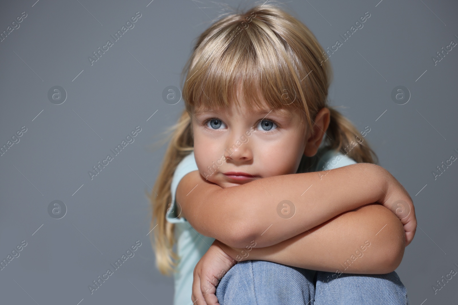 Photo of Orphanage concept. Sad little girl on grey background