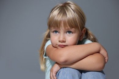 Photo of Orphanage concept. Sad little girl on grey background