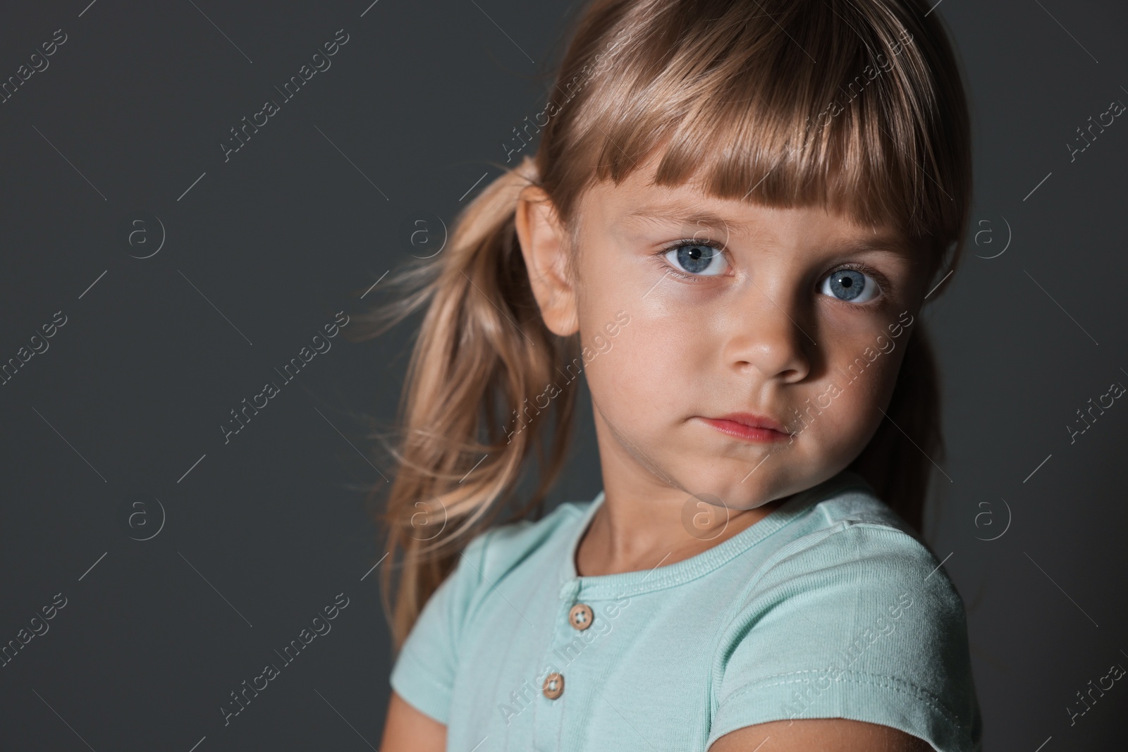 Photo of Orphanage concept. Sad little girl on grey background