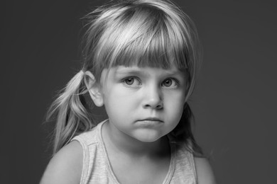 Photo of Orphanage concept. Sad little girl on dark background. Black and white effect