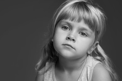 Photo of Orphanage concept. Sad little girl on dark background. Black and white effect