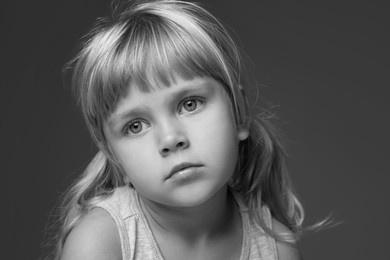 Photo of Orphanage concept. Sad little girl on dark background. Black and white effect