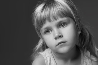 Photo of Orphanage concept. Sad little girl on dark background. Black and white effect