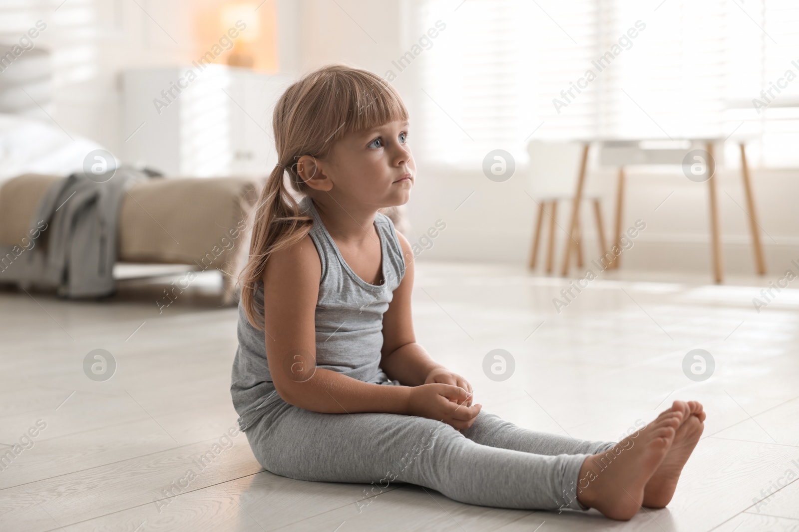 Photo of Orphanage concept. Sad little girl on floor indoors