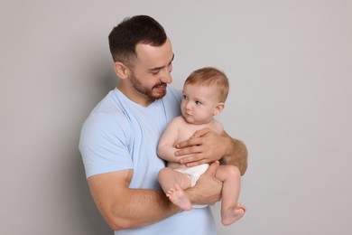 Photo of Father with his cute baby on grey background